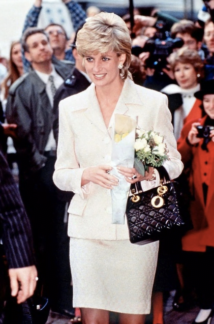 Princess Diana in a white dress, Christian Dior sunglasses and a bamboo  handle taupe coloured Gucci bag.