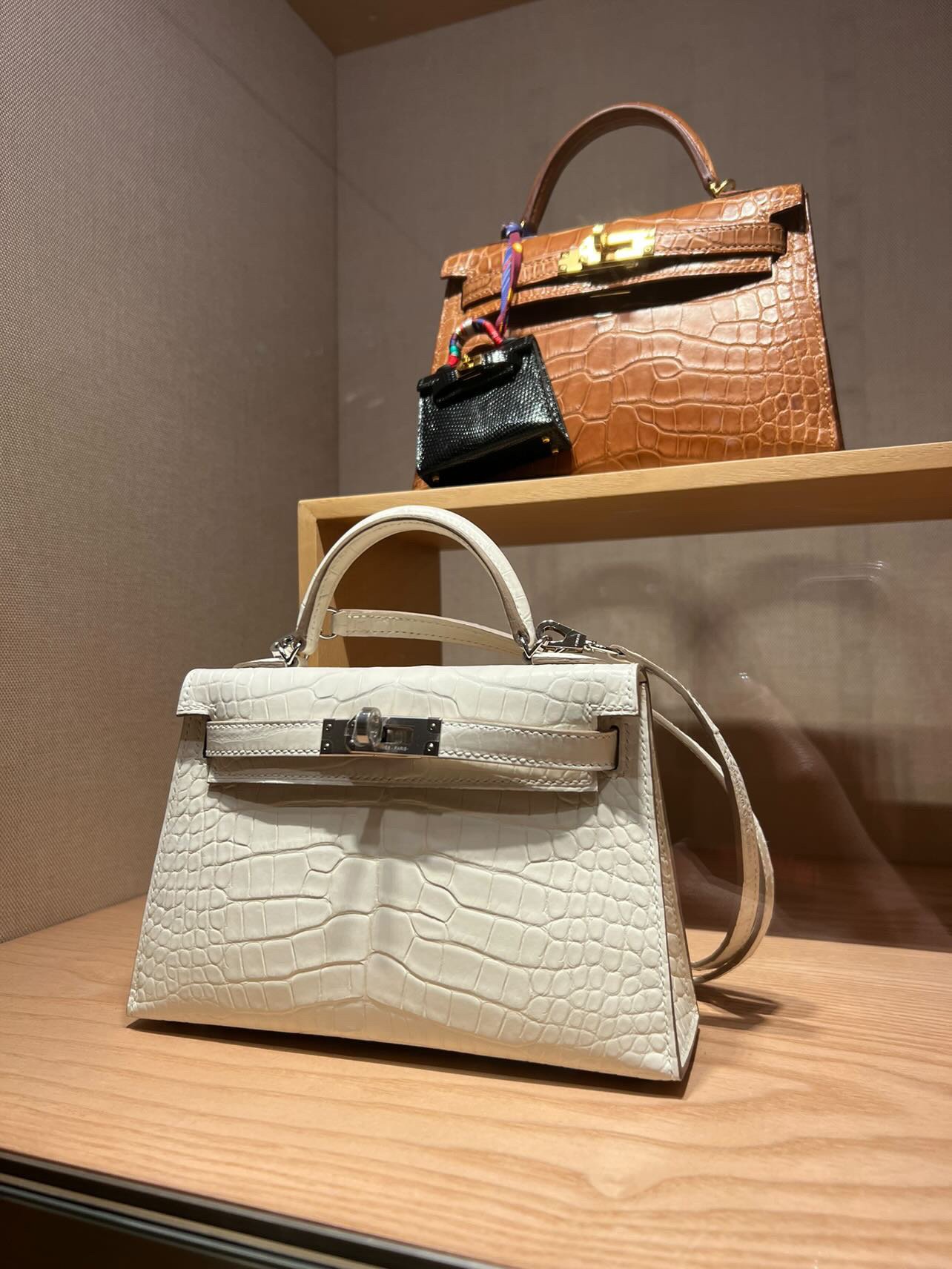 A Birkin luxury handbag sits in the window display of a Hermes